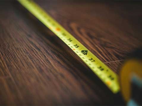 A tape measure extended over a warm, wooden surface